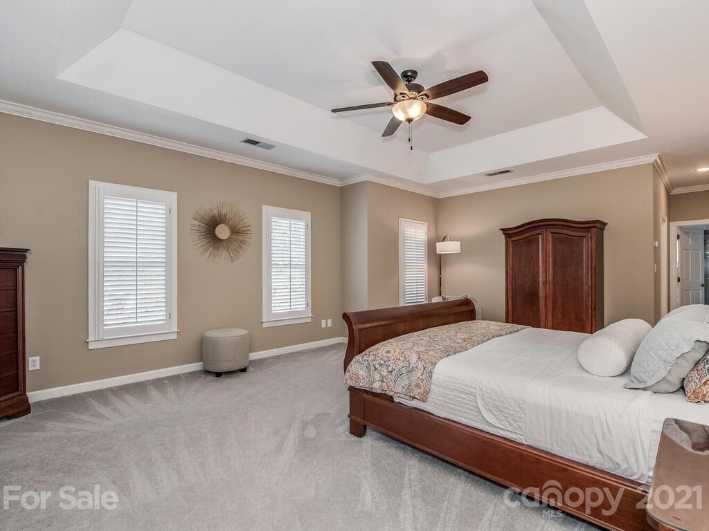 4743 Binfords Ridge Road Charlotte, NC 28226 - Photo 17 of 41 a bedroom with a balcony a bed and a chandelier
