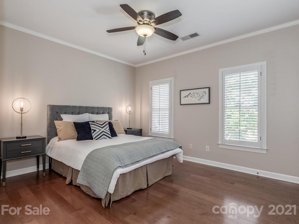 4743 Binfords Ridge Road Charlotte, NC 28226 - Photo 23 of 41 a spacious bedroom with a bed and a chandelier
