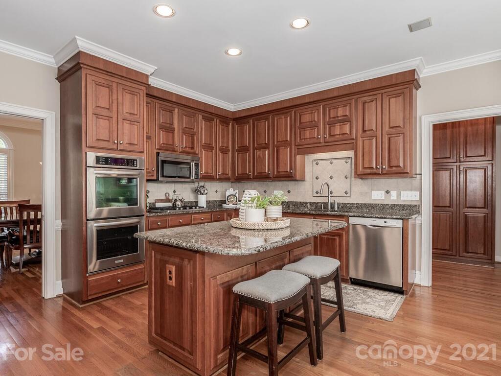 4743 Binfords Ridge Road Charlotte, NC 28226 - Photo 10 of 41 a kitchen with stainless steel appliances granite countertop a stove a sink dishwasher a microwave oven and a refrigerator with wooden floor