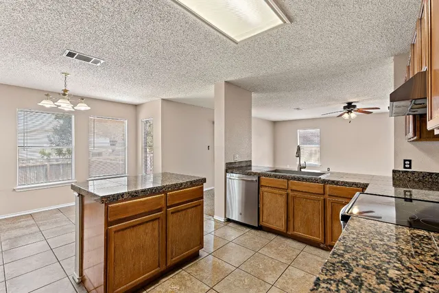 a kitchen with a sink stove top oven and cabinets