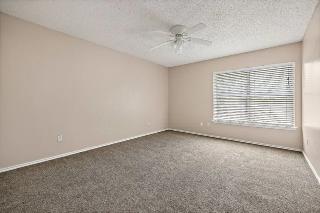 a view of an empty room with a chandelier fan
