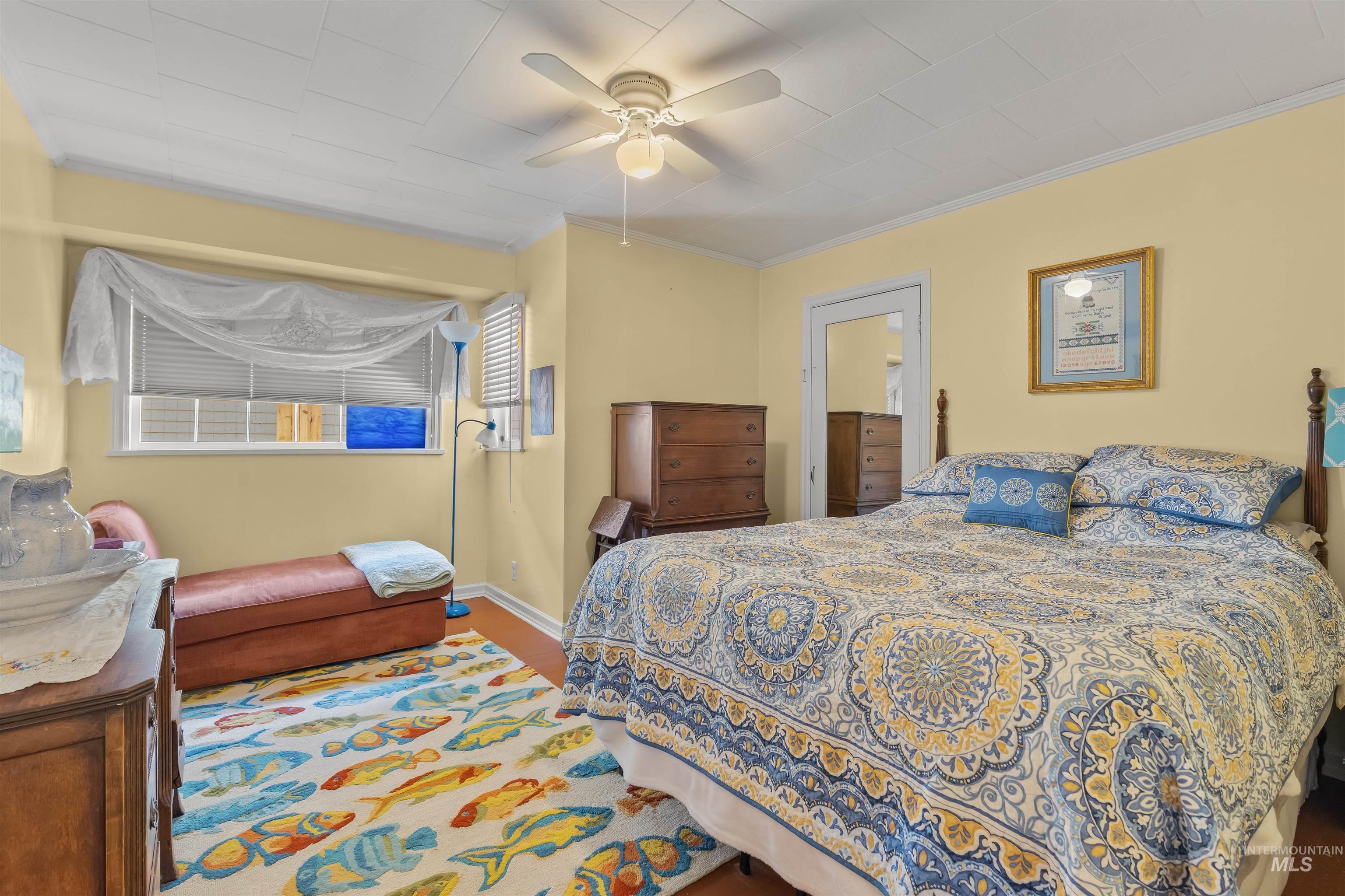 619 Prospect Avenue Lewiston, ID 83501 - Photo 19 of 37 Corner bedroom featuring wood-finish flooring, a ceiling fan with integrated lighting, and yellow painted walls