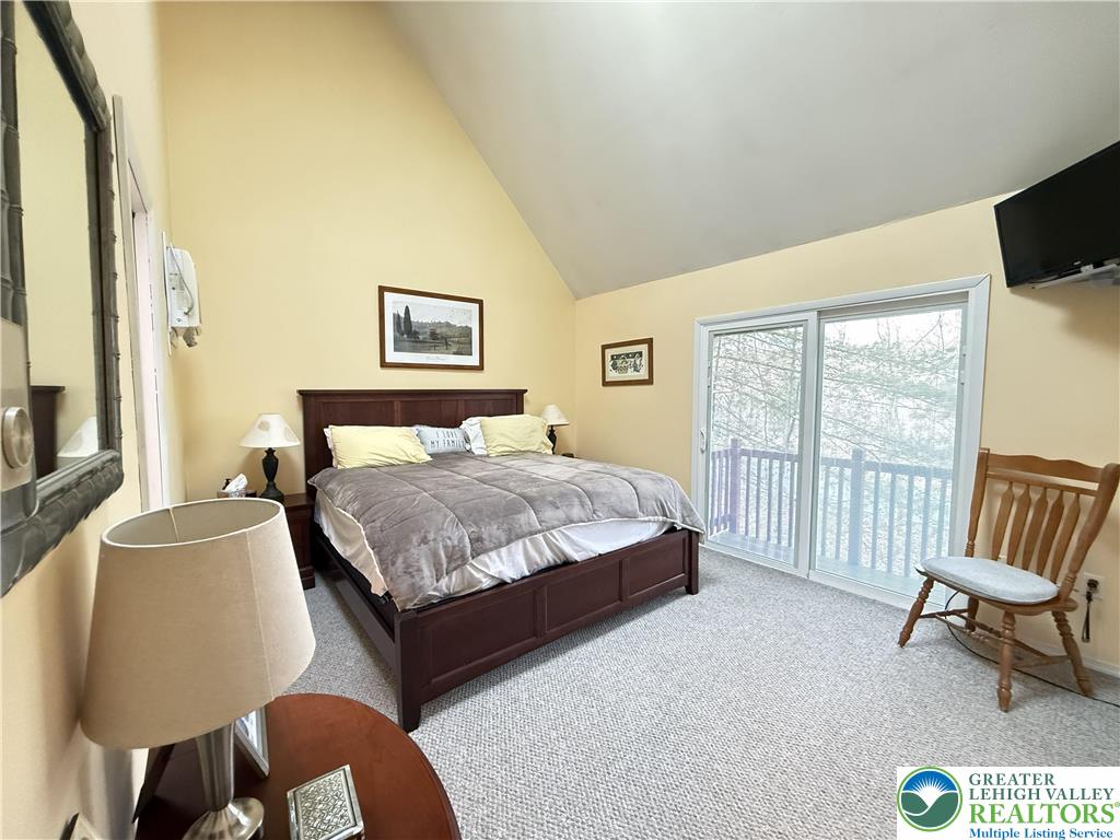 5933 Decker Road Bushkill, PA 18324 - Photo 11 of 51 a bedroom with a bed a chair and a flat screen tv