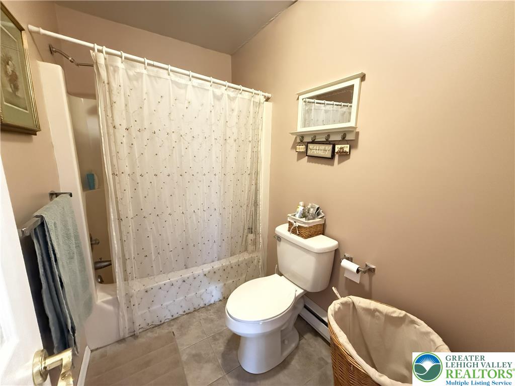 5933 Decker Road Bushkill, PA 18324 - Photo 15 of 51 a white toilet sitting next to a shower curtain