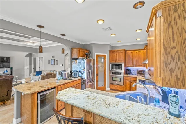 a living room with stainless steel appliances granite countertop furniture and a large window