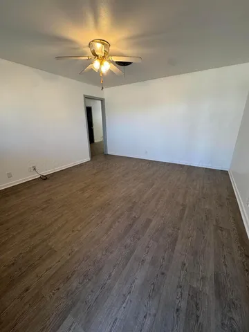 a view of an empty room with a chandelier fan