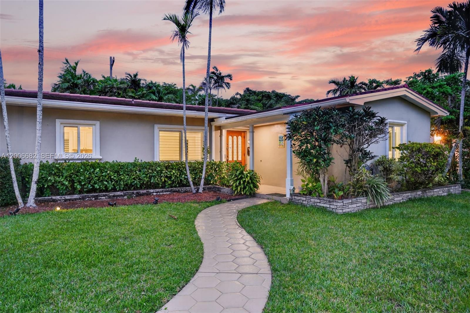 1435 Blue Road Coral Gables, FL 33146 - Photo 1 of 31 a front view of a house with a yard table and chairs