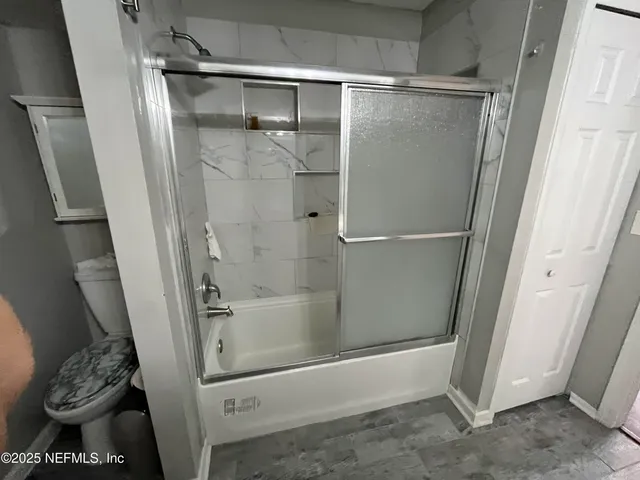 a bathroom with a tub and a glass door