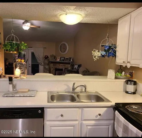 a kitchen with stainless steel appliances granite countertop a refrigerator a stove and a sink