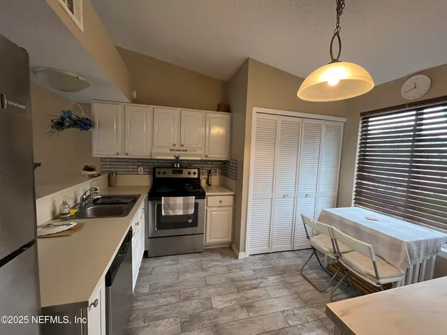a kitchen with a stove a refrigerator and a sink