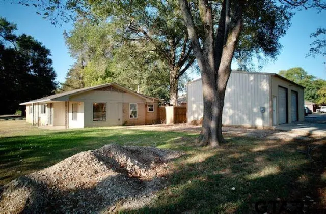 a white house that has tree in front of it
