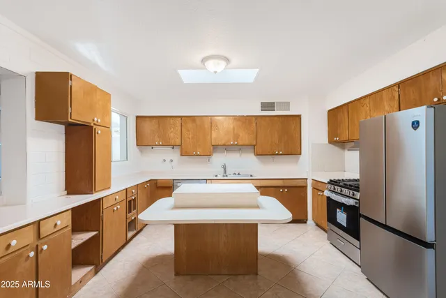 a kitchen with stainless steel appliances granite countertop a sink stove and refrigerator