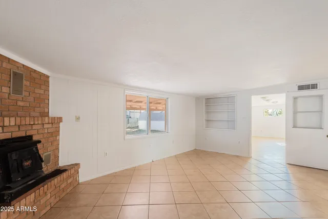 a view of empty room with a fireplace and wooden floor