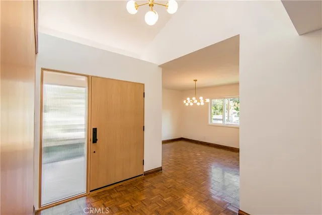 a view of empty room with window and wooden floor