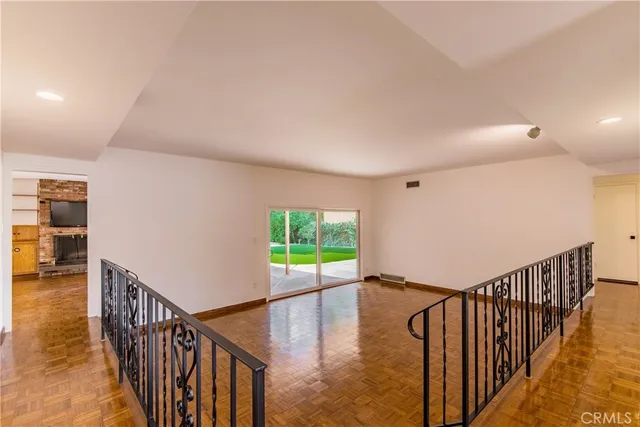 a view of a hallway with wooden floor and stairs