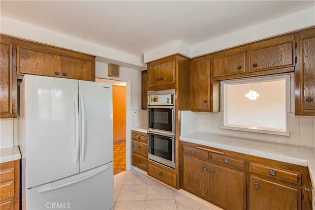 a kitchen with stainless steel appliances granite countertop a refrigerator and a stove top oven