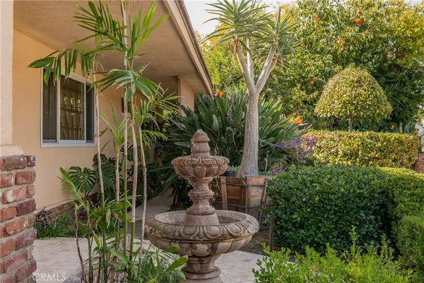 a view of a patio with table and chairs potted plants and large tree