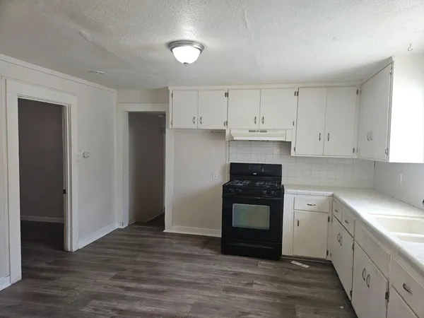a kitchen with granite countertop white cabinets and stainless steel appliances