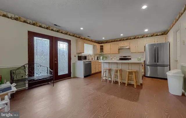 a kitchen with refrigerator and chairs