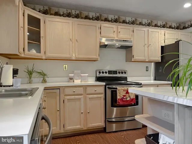 a kitchen with stainless steel appliances granite countertop a sink stove and cabinets