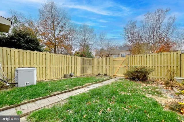 a view of backyard with wooden fence