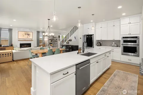 a kitchen with a sink a stove and chairs