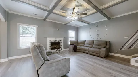 a living room with furniture a fireplace and a flat screen tv