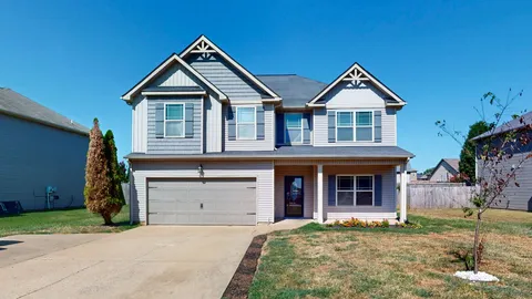 a view of a house with a yard and furniture