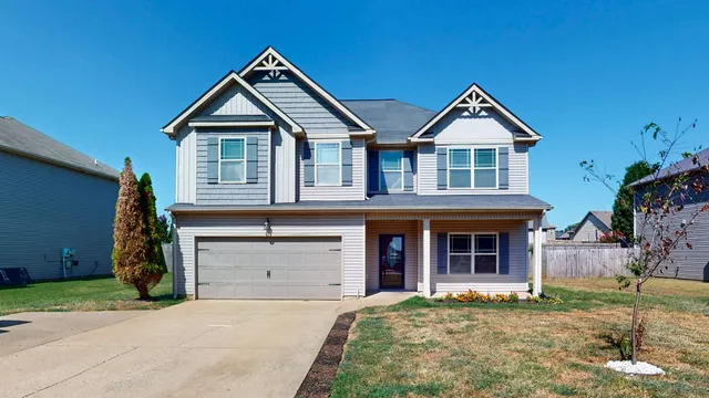 a view of a house with a yard and furniture