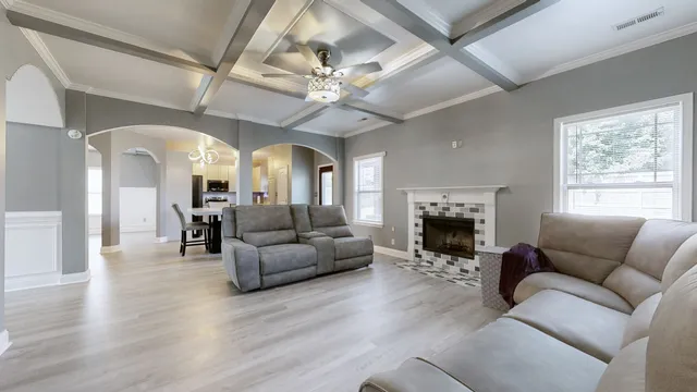 a living room with furniture a fireplace and a large window