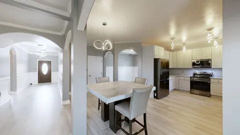 a kitchen with stainless steel appliances a stove a sink dishwasher a refrigerator white cabinets and wooden floor