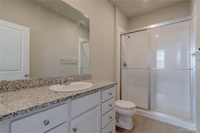 a bathroom with a granite countertop sink toilet and shower