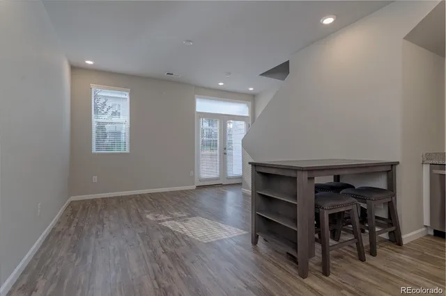 an empty room with wooden floor closet and windows