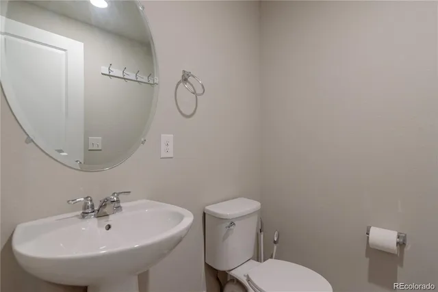 a bathroom with a sink a toilet and a mirror