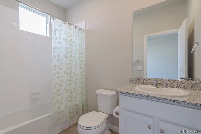 a bathroom with a granite countertop sink toilet a mirror and shower