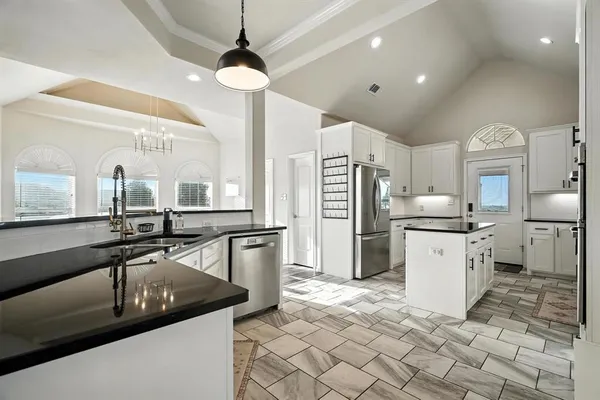 a kitchen with a sink a counter top space appliances and cabinets