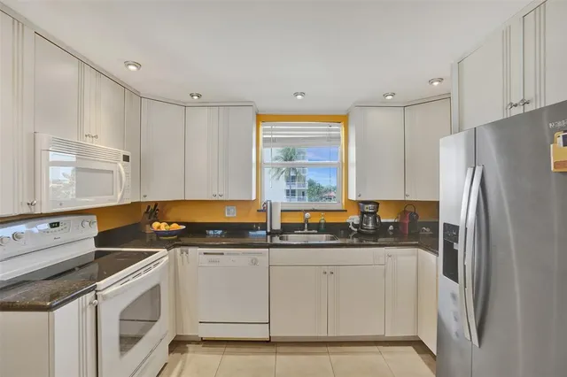 a kitchen with stainless steel appliances a refrigerator sink and cabinets