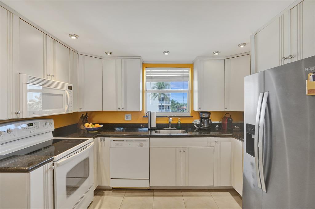 1051 Hillsboro Mile, Unit 307E Hillsboro Beach, FL 33062 - Photo 12 of 30 a kitchen with stainless steel appliances a refrigerator sink and cabinets