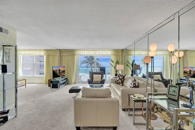 a living room with fireplace furniture and a large window
