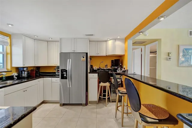 a kitchen with stainless steel appliances granite countertop a refrigerator and a stove top oven