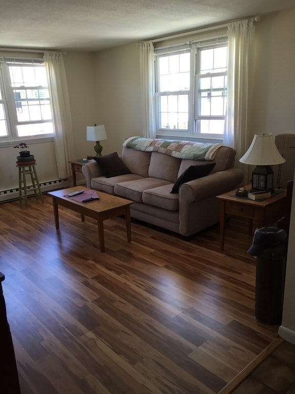 65 Leonard Road, Unit 65 Boxborough, MA 01719 - Photo 2 of 14 a living room with furniture a wooden floor and a window
