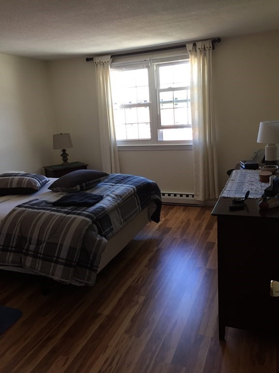 65 Leonard Road, Unit 65 Boxborough, MA 01719 - Photo 6 of 14 a bedroom with a bed and wooden floor