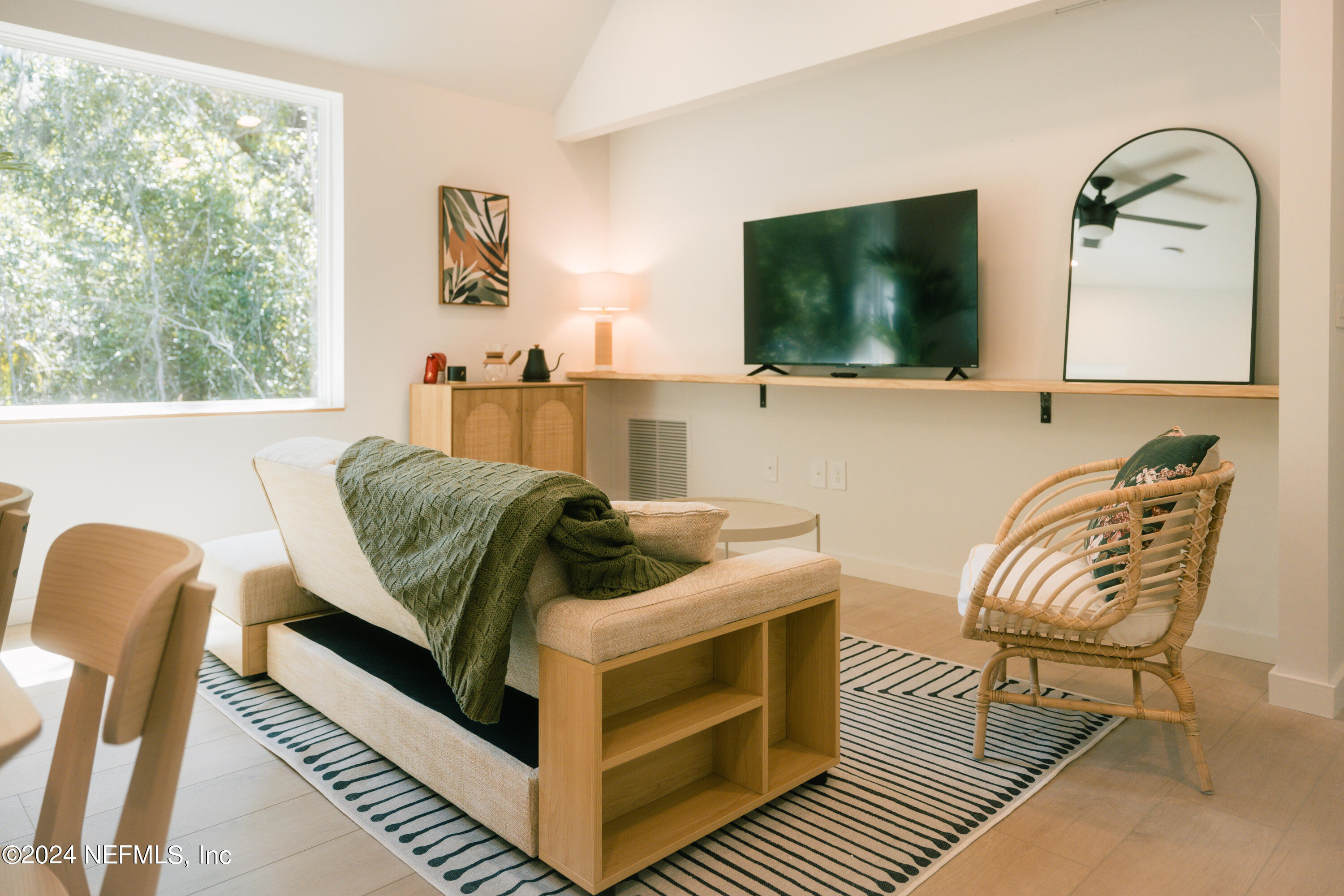 793 Chapin Street St. Augustine, FL 32084 - Photo 8 of 32 a living room with furniture a flat screen tv and a floor to ceiling window