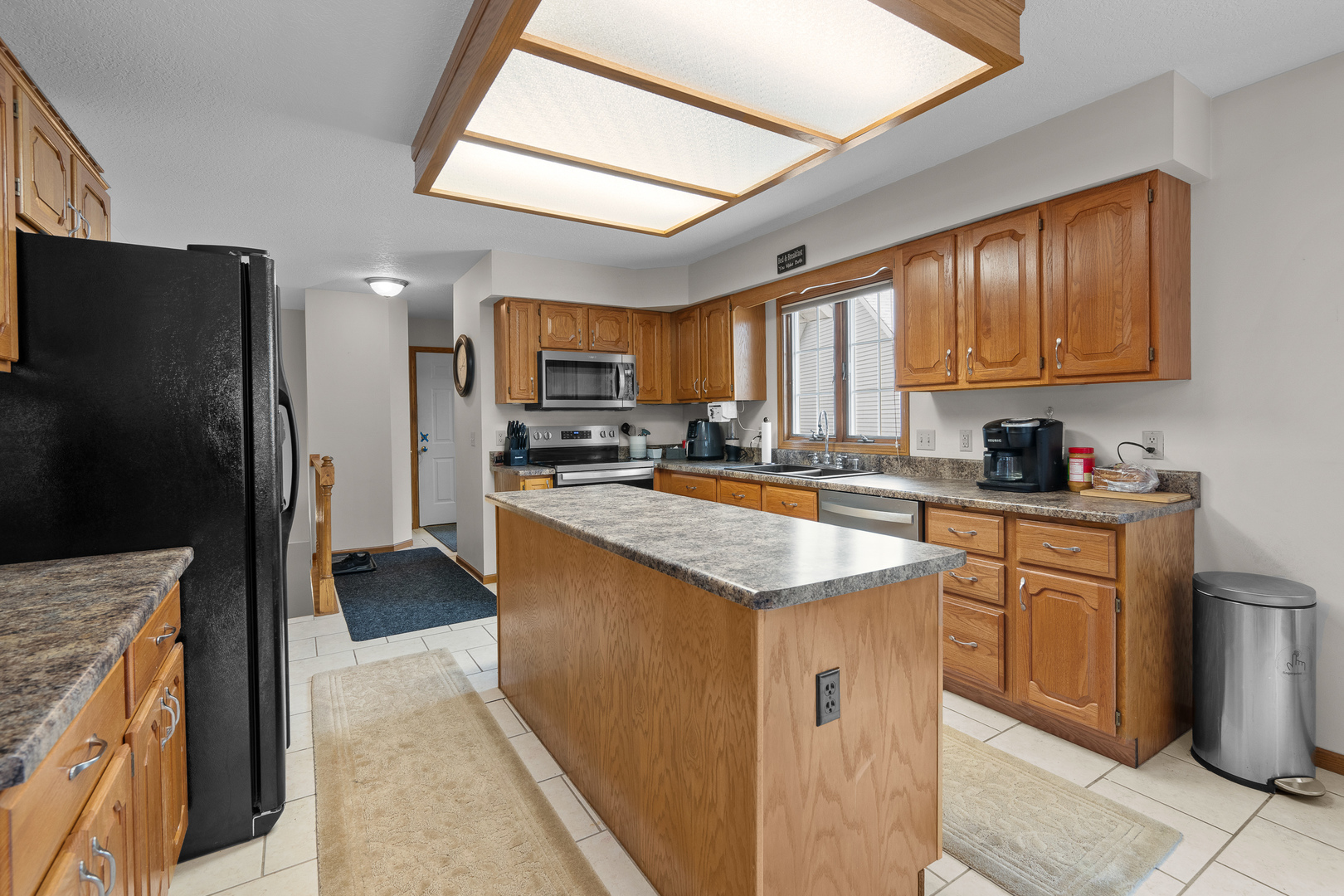 6002 Oakbrook Road Davenport, IA 52806 - Photo 12 of 50 a kitchen with stainless steel appliances granite countertop a refrigerator stove microwave and sink