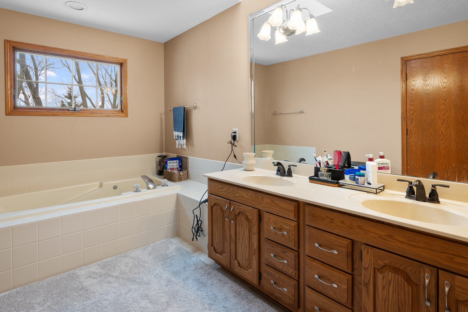 6002 Oakbrook Road Davenport, IA 52806 - Photo 30 of 50 a bathroom with a tub double sink window and mirror