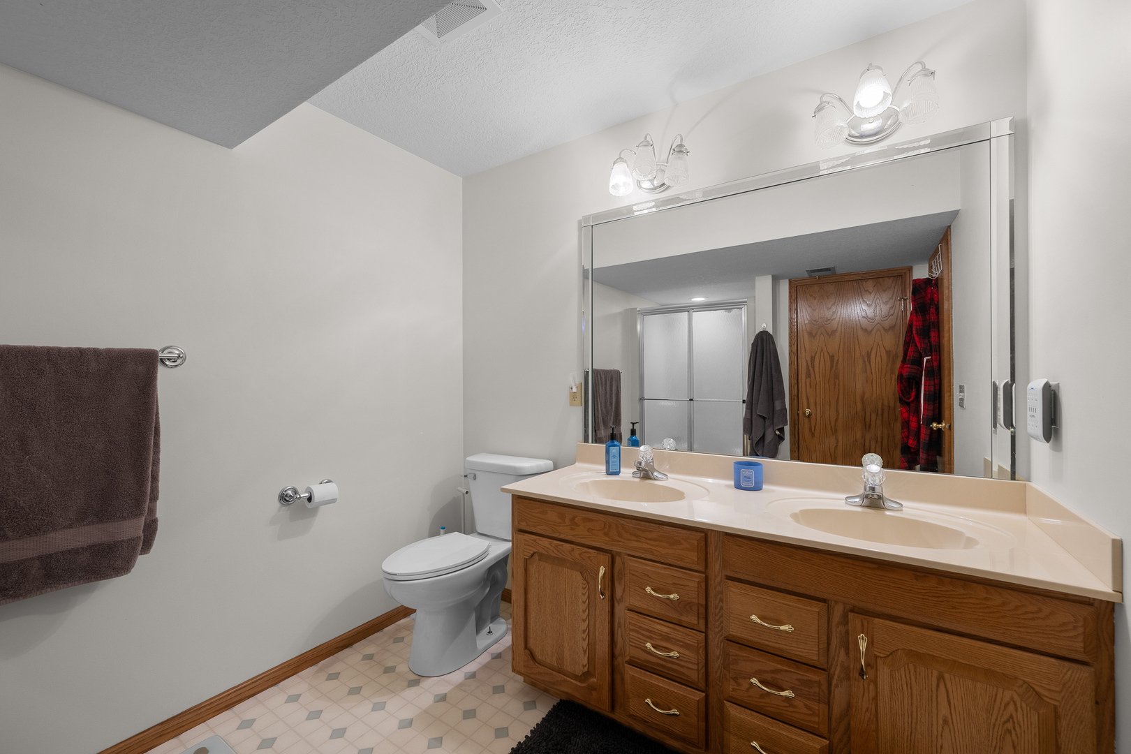 6002 Oakbrook Road Davenport, IA 52806 - Photo 46 of 50 a bathroom with a double vanity sink toilet and a mirror