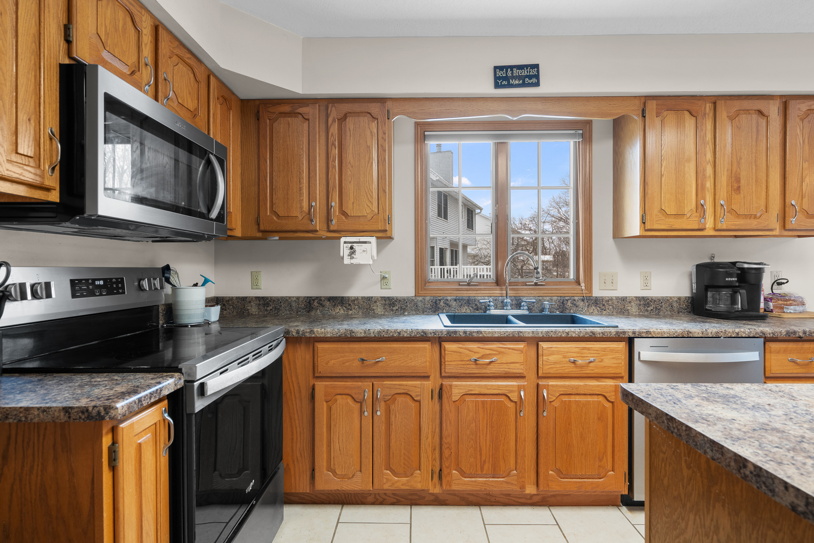 6002 Oakbrook Road Davenport, IA 52806 - Photo 9 of 50 a kitchen with granite countertop a stove a sink and a granite counter tops