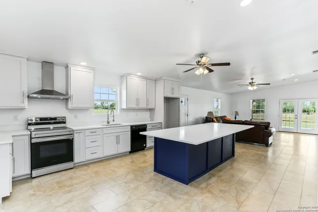 a large kitchen with kitchen island a sink stainless steel appliances and cabinets