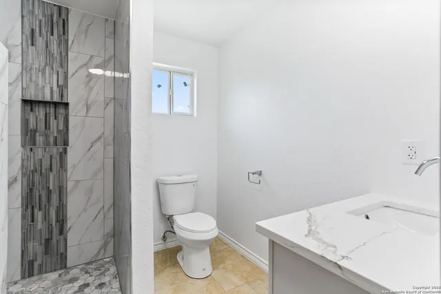 a bathroom with a sink toilet and shower