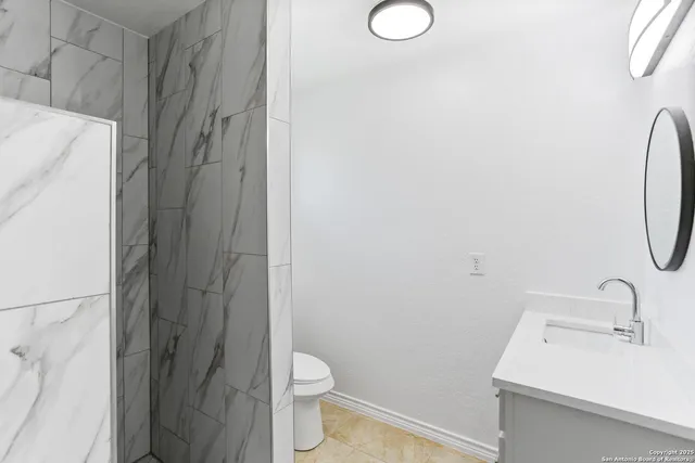 an empty room with windows and ceiling fan